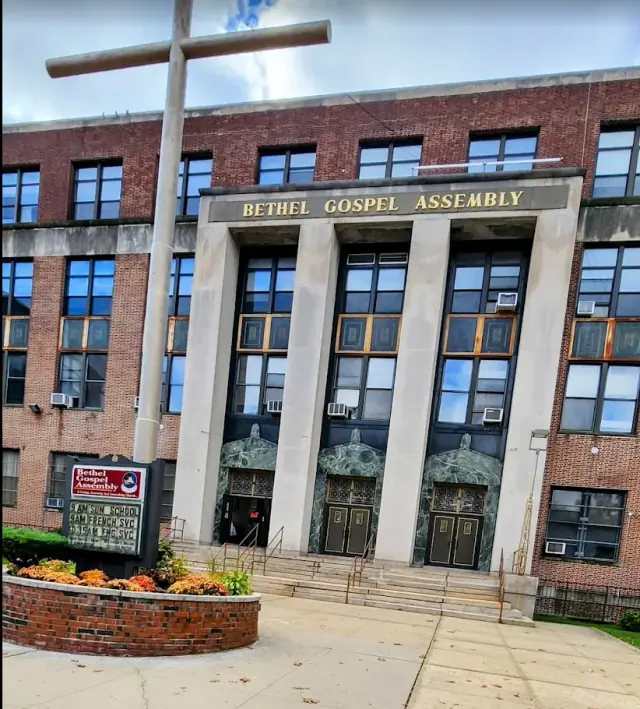 The Bethel Gospel Assembly building: a tall cross in front of the columned entrance